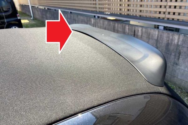 赤い矢印は、車の屋根とリアスポイラーの間の隙間を指しています。.