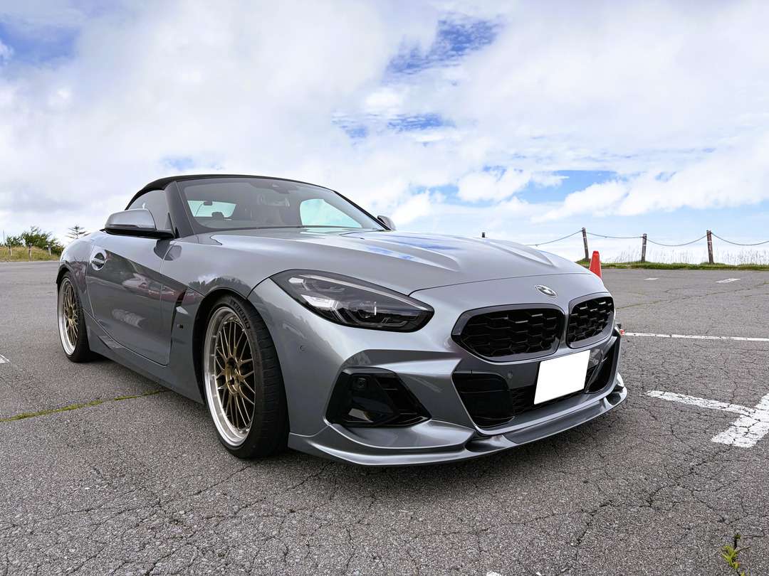 駐車場に停まる、グレーのオープンスポーツカーを前方斜めから見た様子