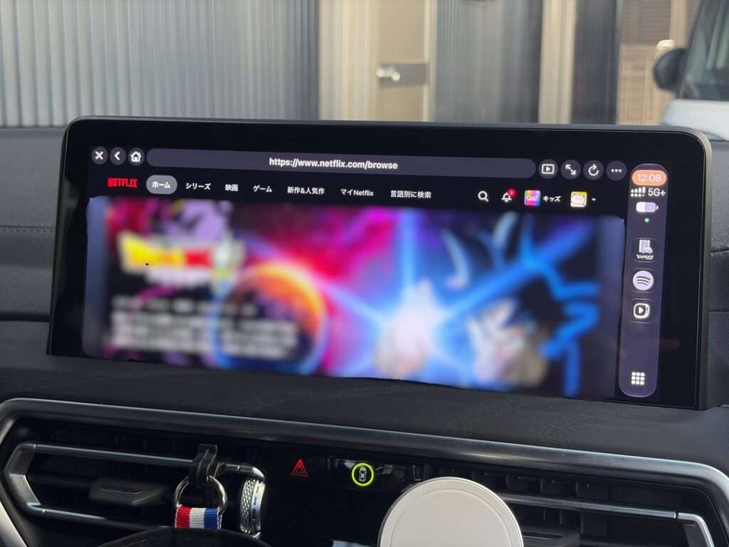 車のダッシュボードにあるディスプレイでNetflixのホーム画面を表示している。