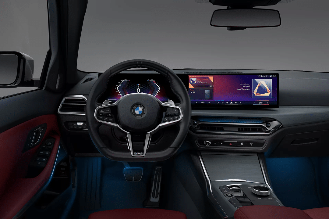 BMW車の運転席から見た内装。ステアリングホイール、デジタルメーター、センターディスプレイを備える。