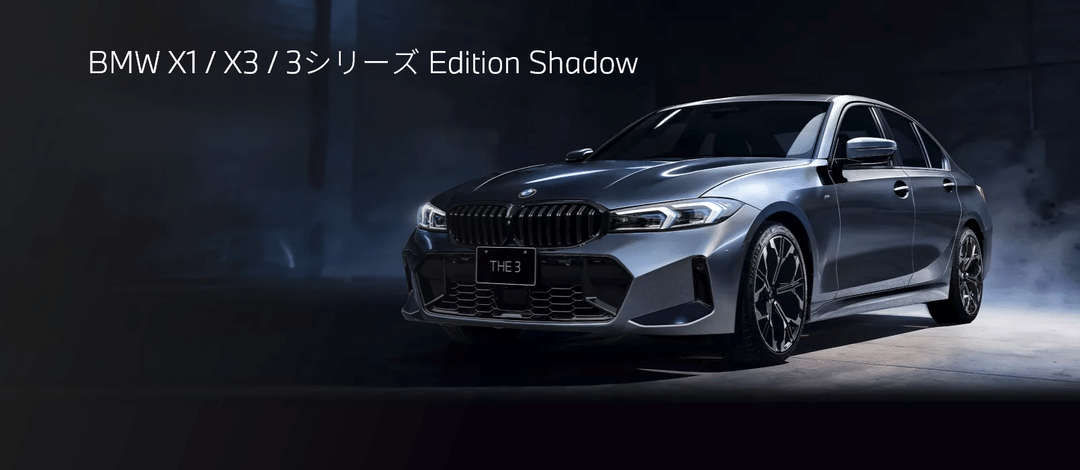 BMW X1/X3/3シリーズ Edition Shadowの広告。暗いスタジオにBMW 3シリーズのセダンが展示されている。