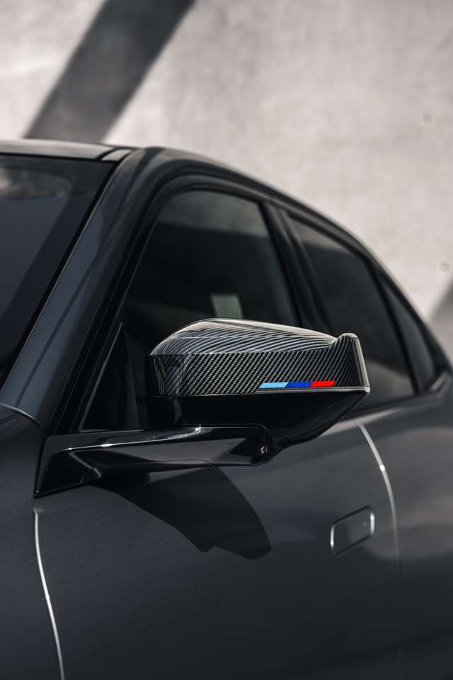 黒い車のカーボンファイバー製サイドミラー。青・白・赤のストライプが入っている。