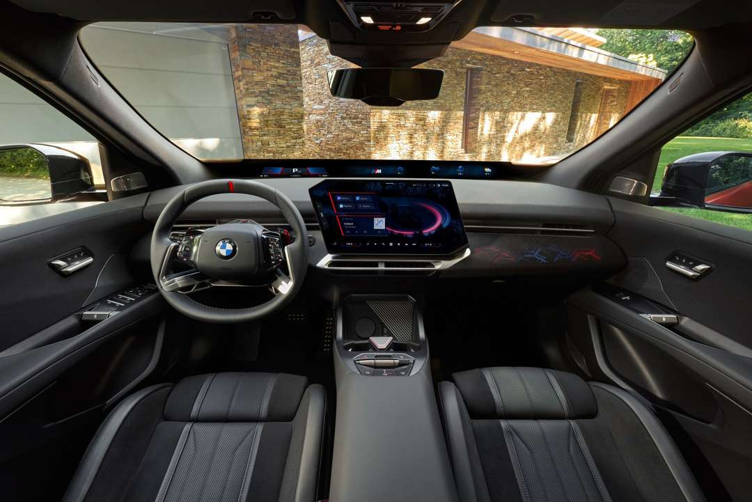 BMW車の運転席から見た、ステアリング、ディスプレイ、センターコンソールを備えた黒い内装