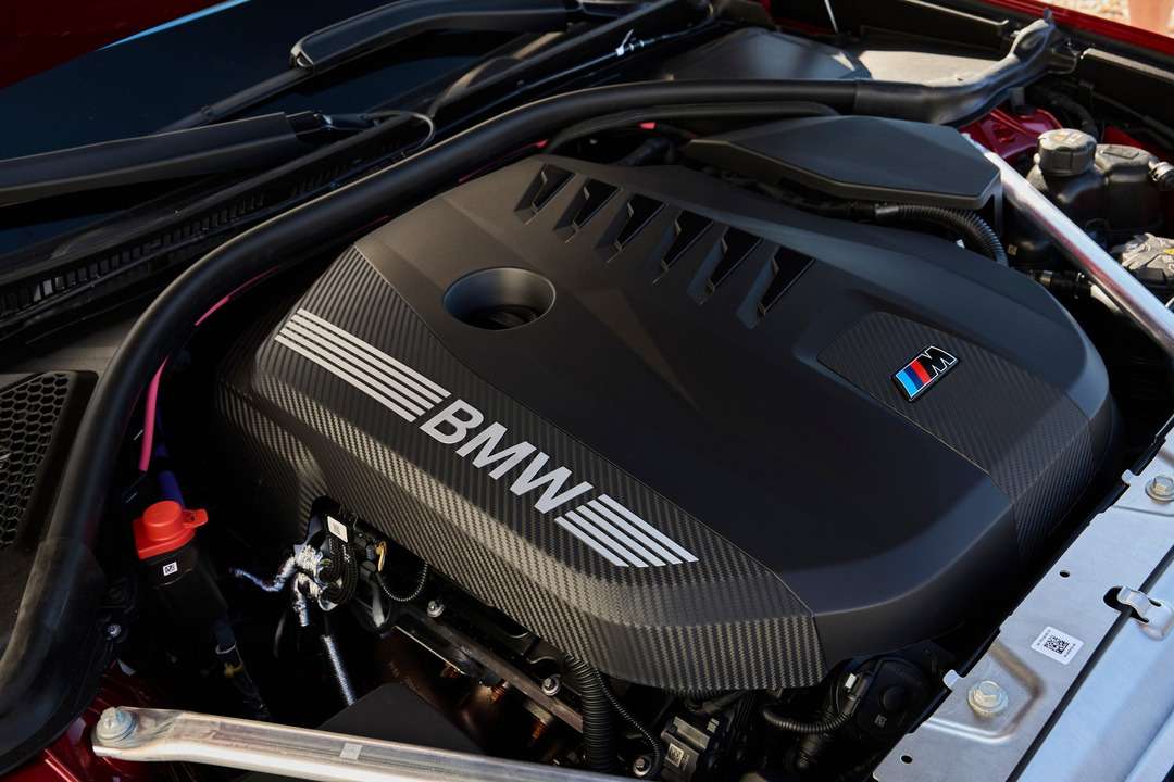 BMW Mロゴと「BMW」の文字が入ったエンジンカバーを備えた自動車のエンジンルーム