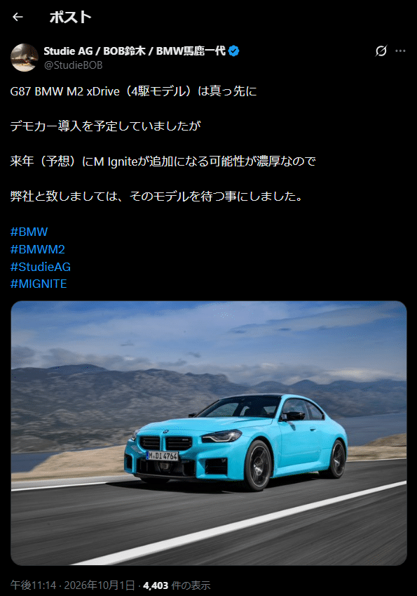 山を背景に道路を走る鮮やかな水色のBMW M2クーペ