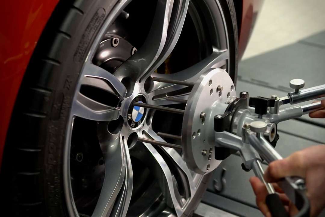 BMWのホイールに整備用の測定装置を取り付けている様子